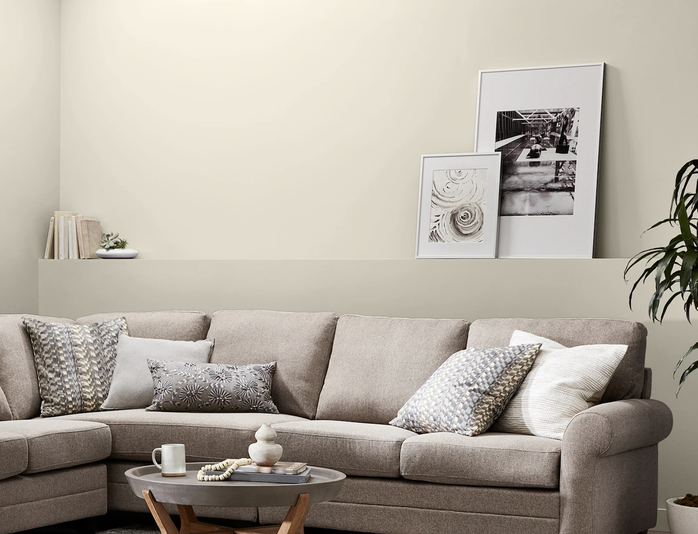 Living room with earthy decorations and beige sofa painted in Cream in My Coffee by Valspar.